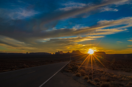 Dusk,sunset at Forest Gump Point with Monument Valley spires and mesas in background in Arizona in western USA of North America. Nearest cities, and attractions are Grand Canyon National Park, Arches National Park, Phoenix, Arizona, Denver, Colorado, Las Vegas, Nevada and Salt Lake City Utah.