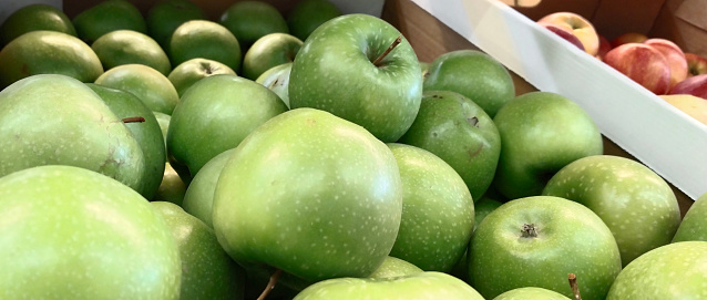 Green apples in box on supermarket shelves. Retail industry. Local Farmers market. Discount. Grocery store. Healthy products. Food suppliers. Greenhouse. Inflation concept. warehouse. Fruit suppliers.