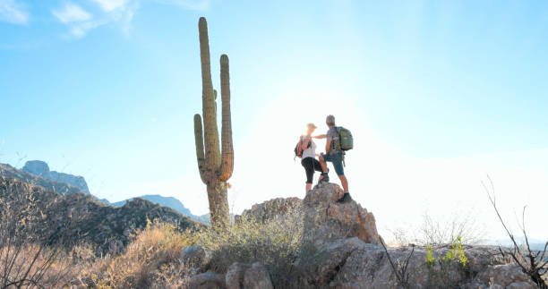 istock Hikers pause on rock in desert 1885421133