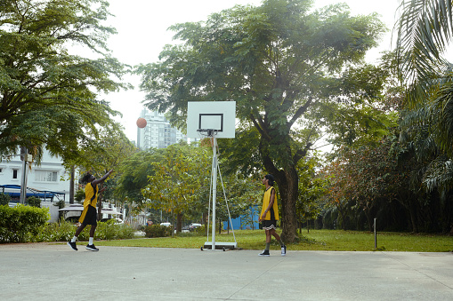 Black men enjoying playing streetball after work on local court