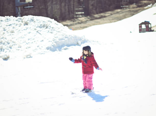 istock Young girl on a ski slope learning how to ski 1885442747
