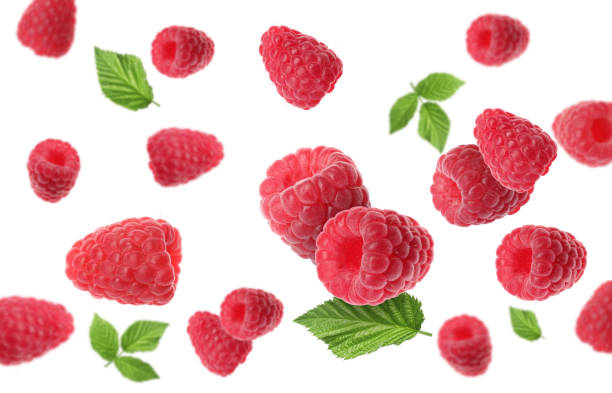 istock Fresh ripe raspberries and green leaves falling on white background 1885452151