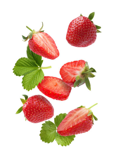 istock Fresh ripe strawberries and green leaves falling on white background 1885452679