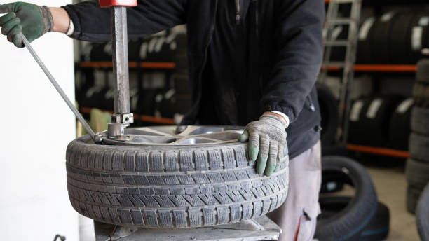 istock Close-up Tire man changing tires in workshop 1885457510