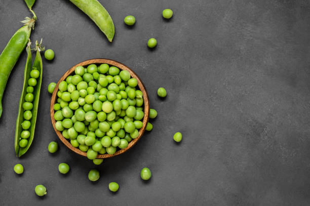 fresh green peas with pod in wooden bowl on rustic background, healthy green vegetable or legume ( pisum sativum ) - green pea pea pod salad legume imagens e fotografias de stock