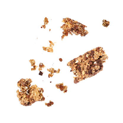 Granola bar breaking in air on white background