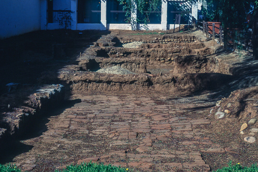 Archaeological excavation of buildings at Mission San Diego de Alcalá, San Diego, California, USA. These ruins are of the monastery, front rooms of the mission built in 1813 and used by visitors or possibly a library. Shows stone foundations for walls and adobe bricks on floors. Excavation was conducted in the 1970s and 80s. Photographed in 1996.