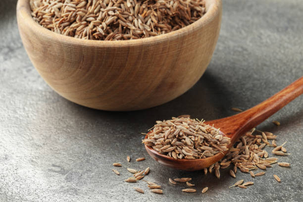 istock Spoon and bowl with caraway seeds on grey table, closeup 1885530227