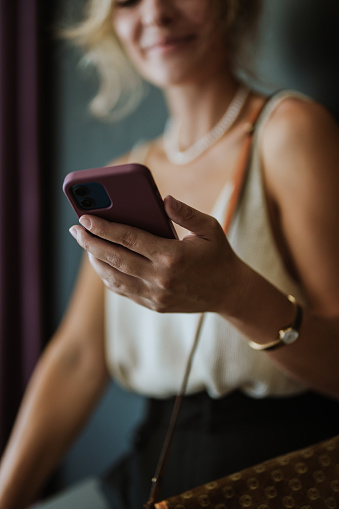 Close up shot of an anonymous woman using her mobile phone for texting or reading a message.