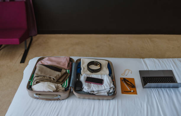 istock Laptop and Open Packed Suitcase on the Bed in the Hotel Room 1885590410