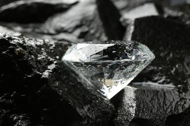 istock Beautiful shiny diamond on wet coal, closeup 1885590947