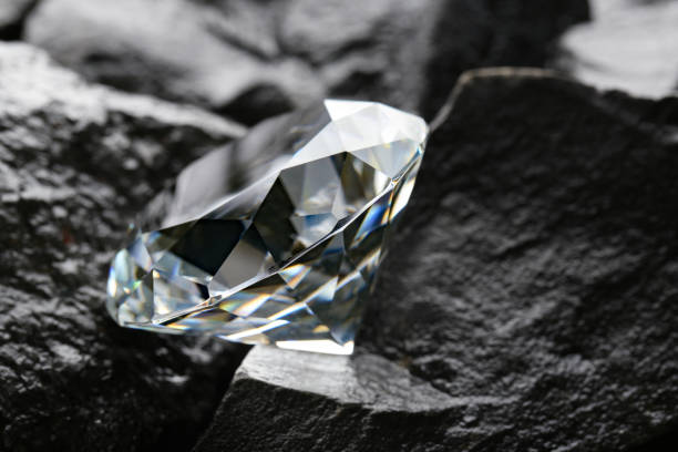 istock Beautiful shiny diamond on coal, closeup view 1885590948