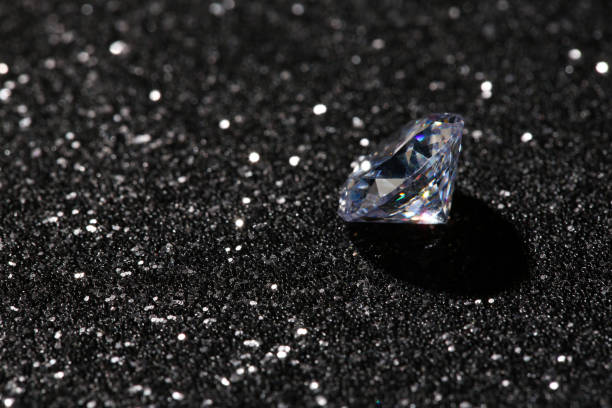 istock Beautiful dazzling diamond on dark shiny background. Space for text 1885591985