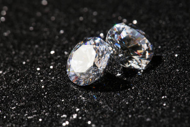 istock Two beautiful diamonds on dark shiny background, closeup 1885591991