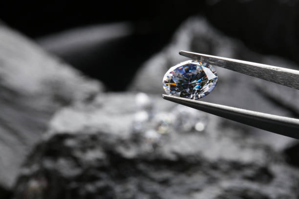 istock Tweezers with beautiful shiny diamond over stones, closeup. Space for text 1885593551