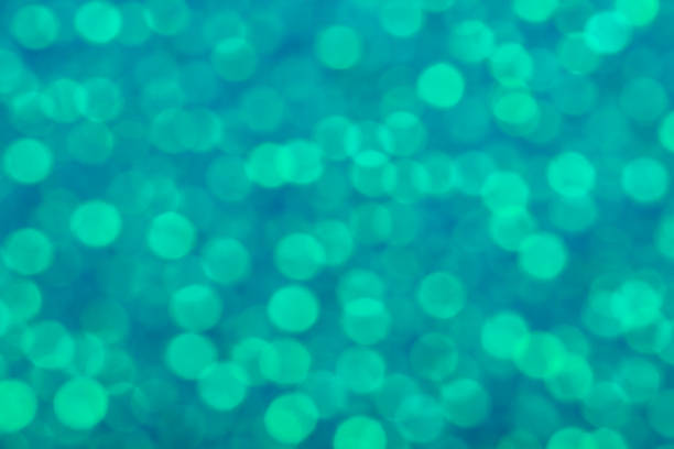 Abstract turquoise bokeh lights. Blurred background texture.