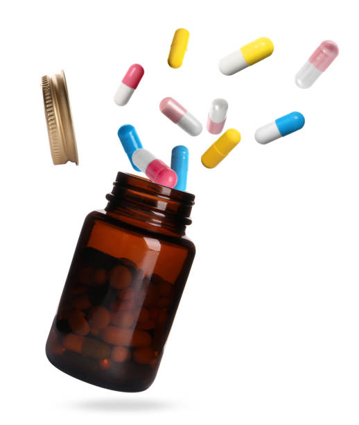 istock Many different colorful pills falling into bottle on white background 1885681831