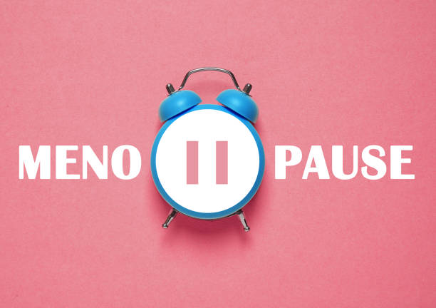 istock Menopause word and alarm clock with pause symbol on coral background, top view 1885686421