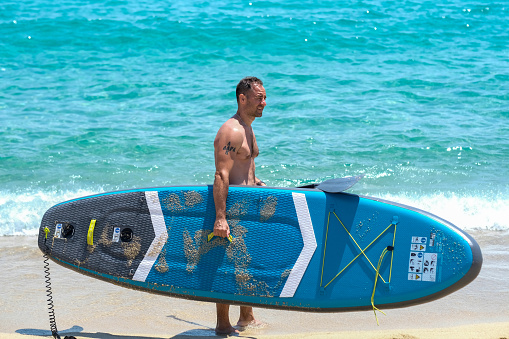 a man prepares to enter the water with a surfboard