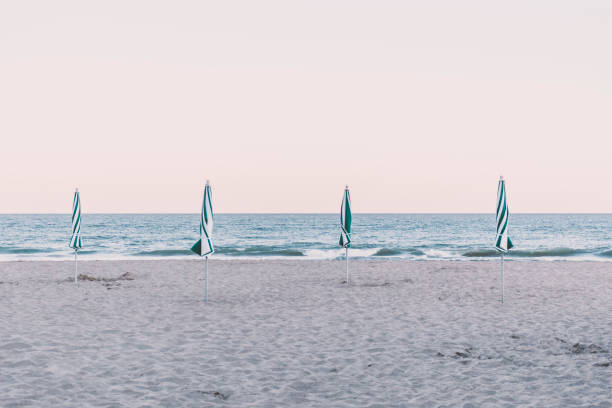 View of four closed beach umbrellas on the shore, Pinamar, Buenos Aires, Argentina.