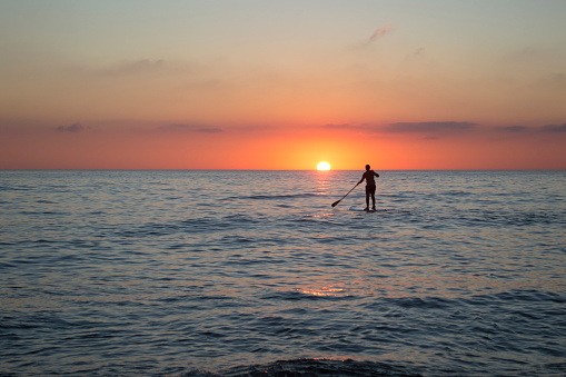 Paddle boarding with sunset at the sea in Solanas beach, Punta del Este