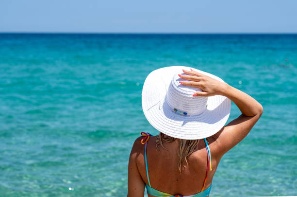 a woman is sunbathing on the beach