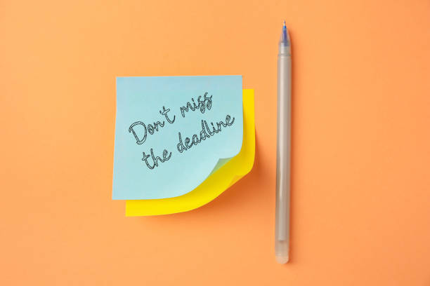 istock Note with reminder Don't Miss The Deadline and pen on orange background, top view 1885709087