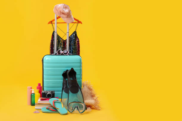 istock Suitcase, clothes and beach accessories on yellow background, space for text. Summer vacation 1885709604
