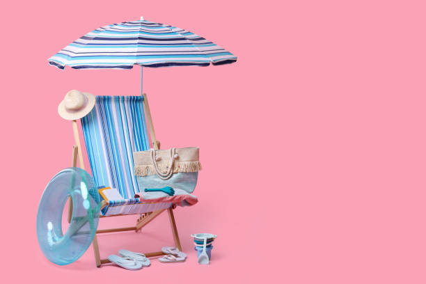 istock Deck chair, umbrella and other beach accessories on pink background, space for text. Summer vacation 1885710677