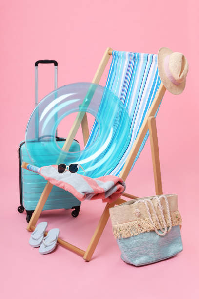 istock Deck chair, suitcase and beach accessories on pink background. Summer vacation 1885711728