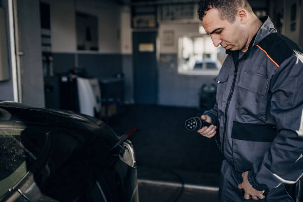 istock Man charging power to electric vehicle 1885734042