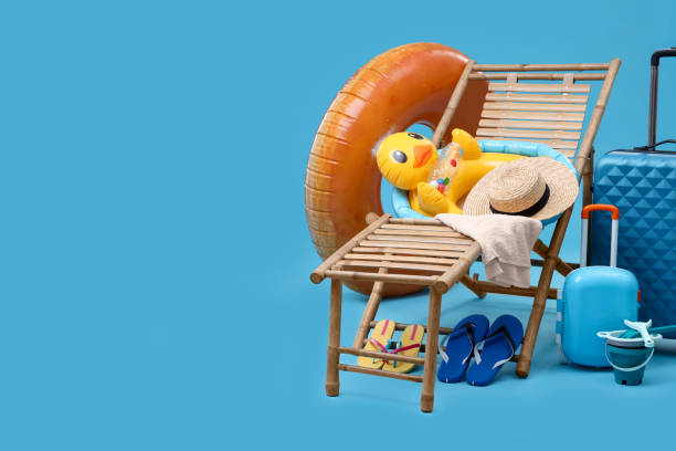 istock Deck chair, suitcases and beach accessories on light blue background, space for text. Summer vacation 1885744884