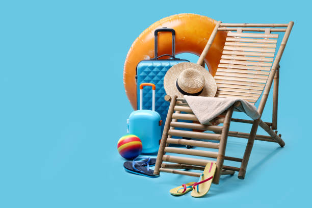 istock Deck chair, suitcases and beach accessories on light blue background, space for text. Summer vacation 1885745407