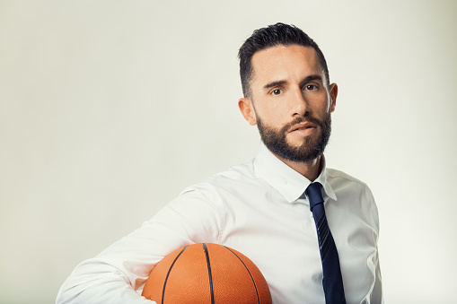 Man in business wear presenting a basketball, a metaphor for strategic planning and execution