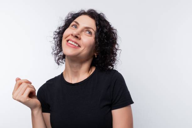 istock Dreamy brunette with curly hairstyle against a copy space background, studio shot 1885871558