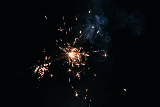 istock Wedding rings on burning bengal light with many sparks on blue background 1885872747