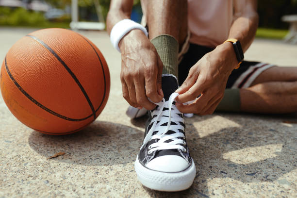 istock Streetball Player Tying Shoe Laces 1885993692