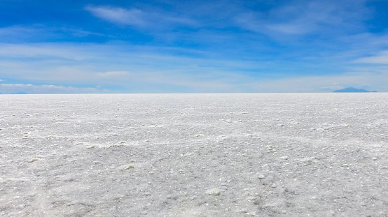 White surface of salt and the blue sky. Endless boundless infinite vastness width expanse dreamy landscape of white salt flat lake Salar de Uyuni in Potosi Bolivia South America