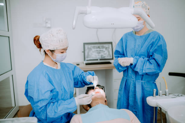 istock Asian Chinese dentist is cleaning patient teeth. 1886087139