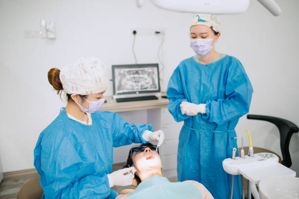 istock Asian Chinese dentist is cleaning patient teeth. 1886087141