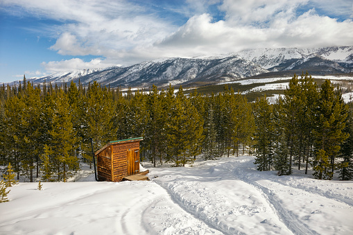 Outhouse with snowy mountains in Colorado in Walden, Colorado, United States