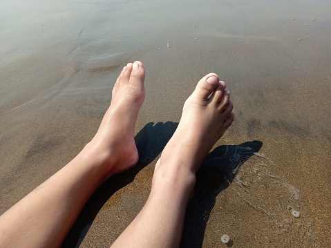 feet relaxing on the beach sand