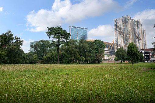 Field with a view of modern apartment buildings with a blue sky background