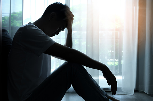 The man sitting in the corner of the room has emotional and mental problems He has depression and stress from society and work. medical concept.