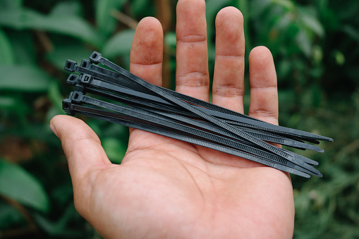 holding black cable tie