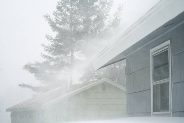strong wind blowing snow off the roof in blizzard