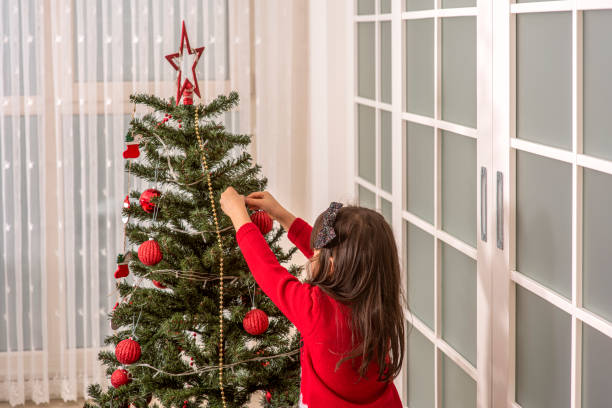 Little girl decorating the Christmas tree