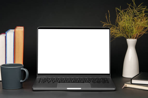 istock Laptop with blank screen on table against black background 1886442722