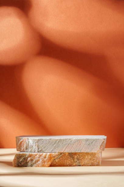istock Piece of granite stone against beige background with shadows 1886467929