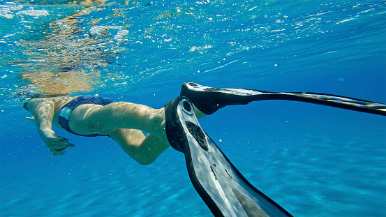 Boy wearing diving flipper while swimming in sea during vacation.